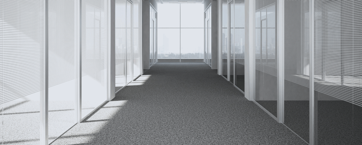 A hallways view of a commercial building with pristine gray carpets to showcase cleaning commercial carpets.