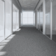 A hallways view of a commercial building with pristine gray carpets to showcase cleaning commercial carpets.