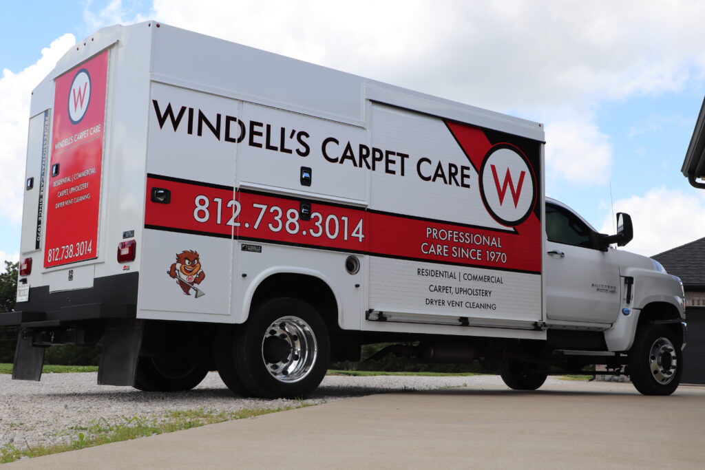 IMG_5008 A white Windell’s Carpet Care truck is parked on a driveway. The truck displays the company name, phone number, and services like carpet, upholstery, and dryer vent cleaning on its side—perfect for anyone searching for answers to their Carpet Cleaning FAQ.
